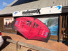 North Nova 2023 5.0m wing foil wing laid flat on the ground outside Board-Worx, showing the red canopy underside and NORTH NOVA branding