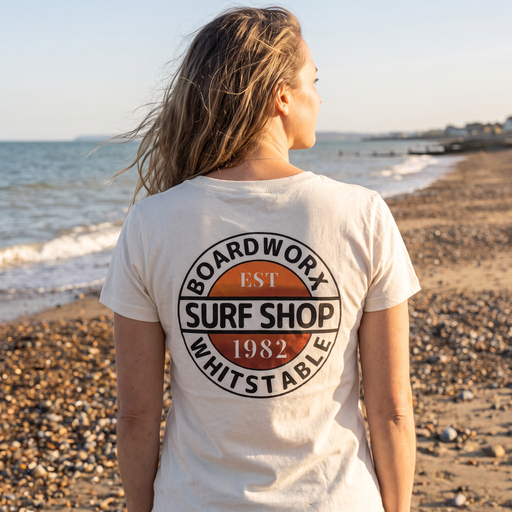 Woman wearing Boardworx Surf Shop Natural Raw V-neck T-shirt on Whitstable beach, back logo view