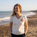 Woman wearing Boardworx Surf Shop Natural Raw V-neck T-shirt on Whitstable beach, front view