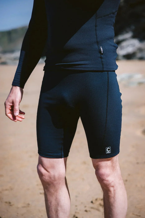 C-Skins black thermal wetsuit under shorts for watersports on sandy beach
