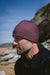 C-Skins Storm Chaser 2mm neoprene beanie in rust, worn outdoors by the beach