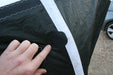 Close-up of a hand inspecting CORE 8M XLite Hydrofoil kite with patch on black fabric