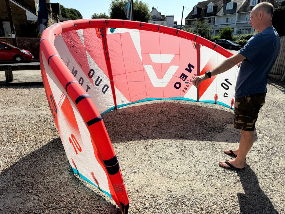 Duotone Neo 2024 10m red kitesurfing kite being inspected outdoors