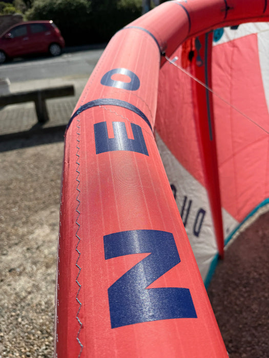 Duotone Neo 2024 10m red kitesurfing kite leading edge with bold blue lettering outdoors
