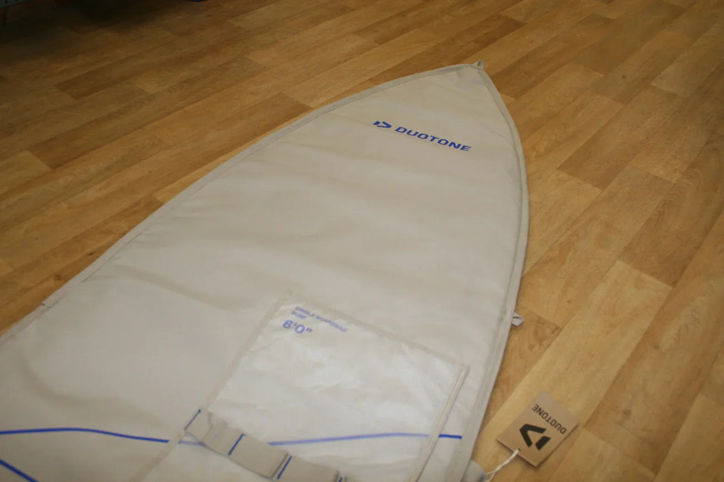 Duotone single surfboard bag 6ft, beige with blue accents, on wooden floor