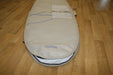 Duotone beige surfboard bag 6ft with blue accents and exterior storage pocket on wood floor