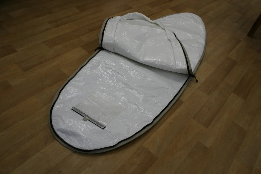 White Duotone single surfboard bag 6ft with black trim, open, on wooden floor