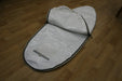 White Duotone single surfboard bag 6ft with black trim, open, on wooden floor