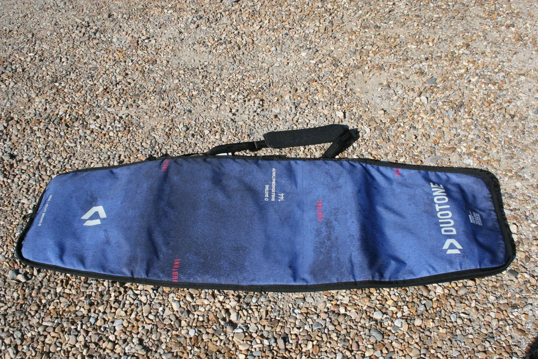 Duotone blue twin tip 143cm board bag with shoulder strap on pebbled ground