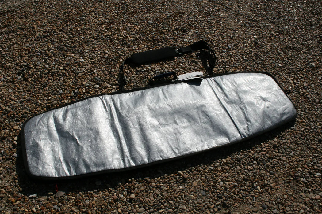 Duotone silver twin tip 143cm board bag with carry handle on pebble ground