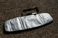 Duotone silver twin tip 143cm board bag with carry handle on pebble ground