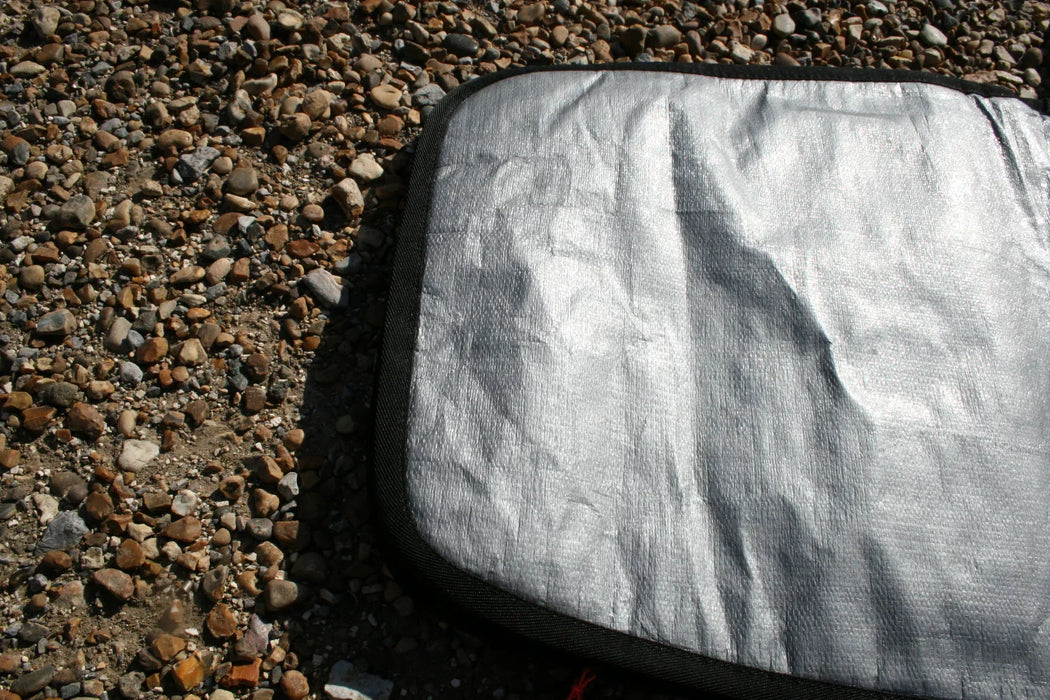 Silver Duotone twin tip board bag on pebbled ground, durable fabric and black trim