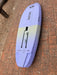 Bottom view of used Duotone Skybrid 5'10" 100L 2025 wing foil board showing foil track slots and light violet colour with yellow-green graphic