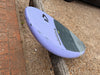 Nose bottom of used Duotone Skybrid 5'10" 100L 2025 wing foil board showing DUOTONE text and light violet finish with minor usage marks