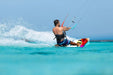 Duotone twintip kiteboard with colourful design in action on clear blue water