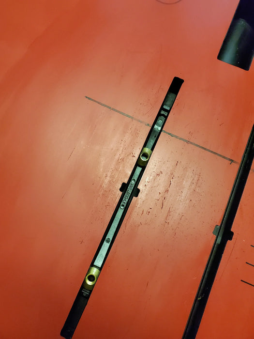 Duotone wing foil track nut sled on red hydrofoil board, close-up hardware detail
