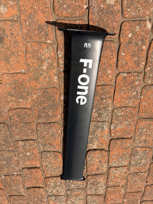 Used F-one Carbon Mast 85cm laid on brick paving showing full side profile with F-one branding and 85 size marking