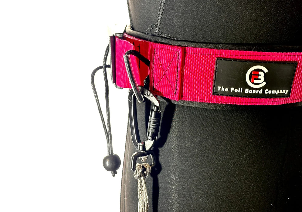 The Foil Board Company red waist leash belt with black carabiner and cord, worn over wetsuit
