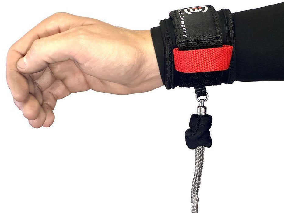 Black wingfoil wrist leash with red strap on wrist, metal swivel and braided cord