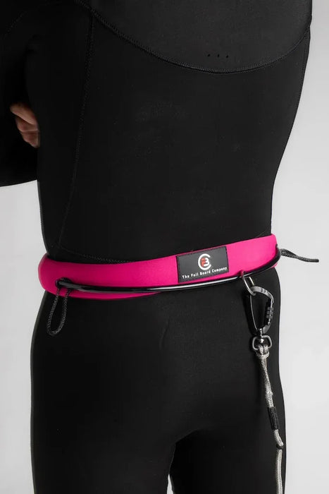 The Foil Board Company pink waist leash for wing foiling, worn over a black wetsuit