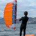 Flysurfer Parawing orange wing foil held by person in wetsuit on water