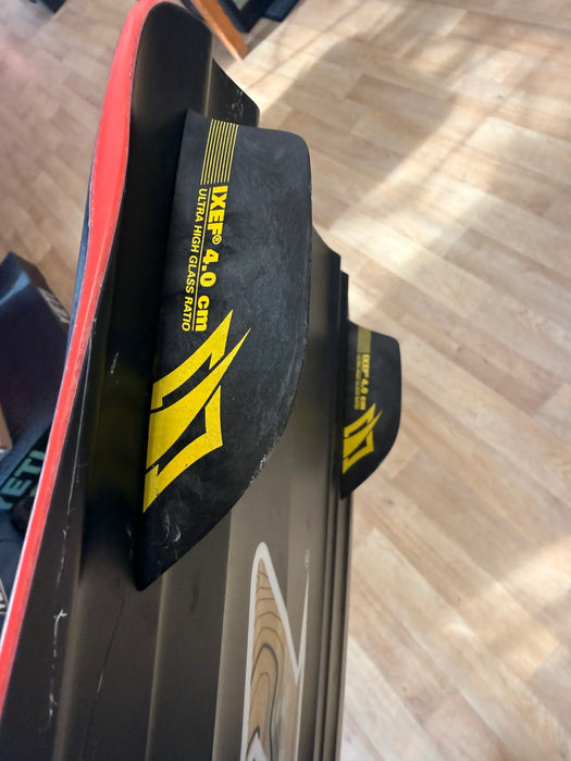 Naish Monarch kitesurfing board black fins with yellow logo and wood pattern on base