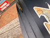 Naish Monarch kitesurfing kite board, black with orange design, detail of fin and logo