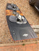Naish Monarch kitesurfing board, black with grey footstraps, seen on a gravel surface
