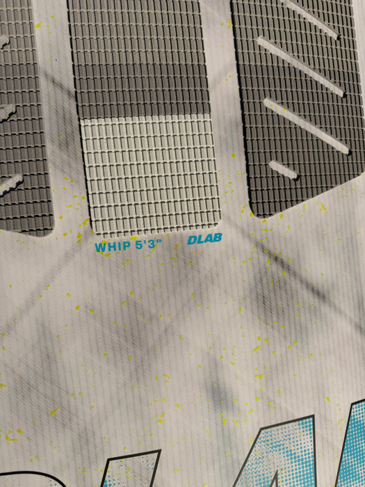 Duotone Whip DLAB 5'3 surfboard close-up with grey deck grip and yellow splatter design