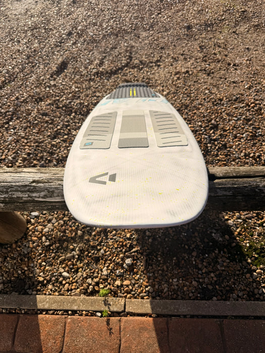 Duotone DLab Whip 5'3 surfboard with textured deck, white and grey, on a wooden rail