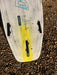 Duotone Whip DLab kite surfboard 5'3 in white with yellow accent on pebbled beach
