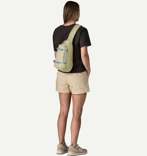 Patagonia Atom Sling 8L weathered stone bag worn by woman, outdoor clothing