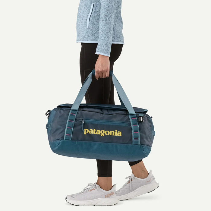 Patagonia Black Hole duffel bag 40L in tidal teal carried by person in sportswear