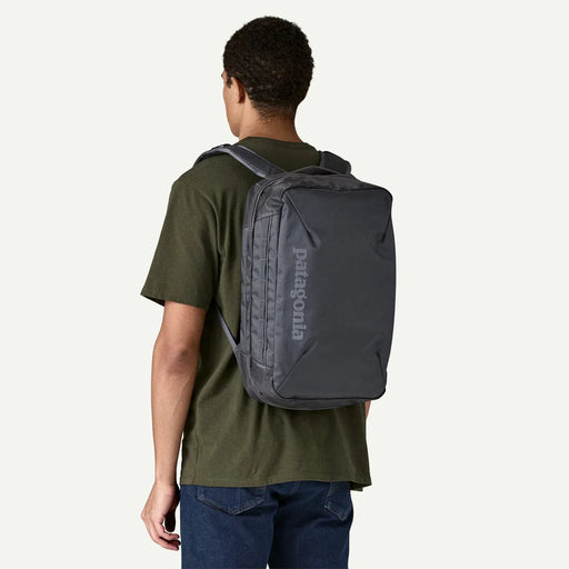 Patagonia black backpack worn by man in green shirt