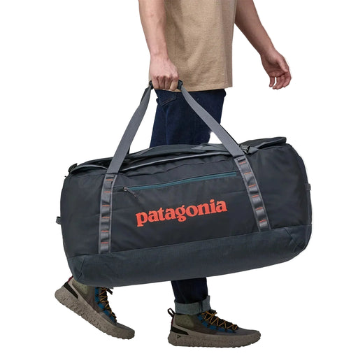 Person holding a Patagonia duffel bag on a white background