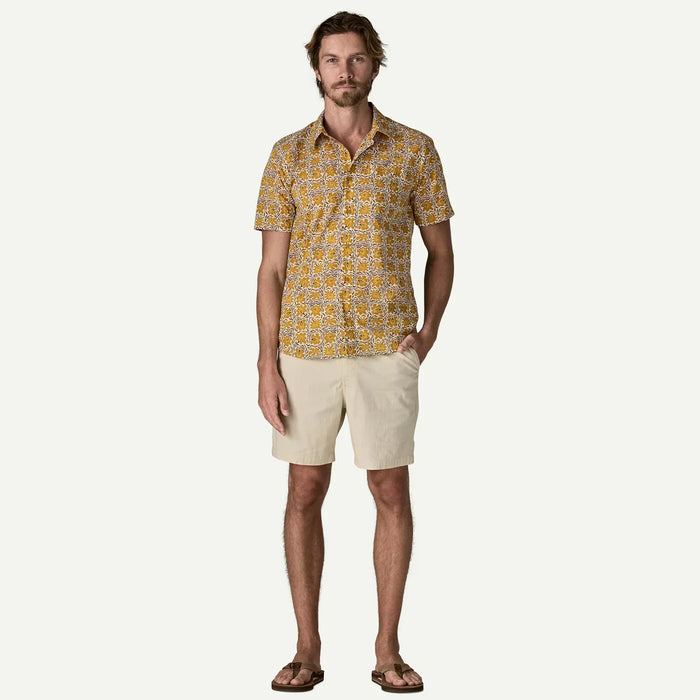 Patagonia men's short sleeve floral shirt in yellow with beige shorts and flip flops