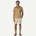 Patagonia men's short sleeve floral shirt in yellow with beige shorts and flip flops
