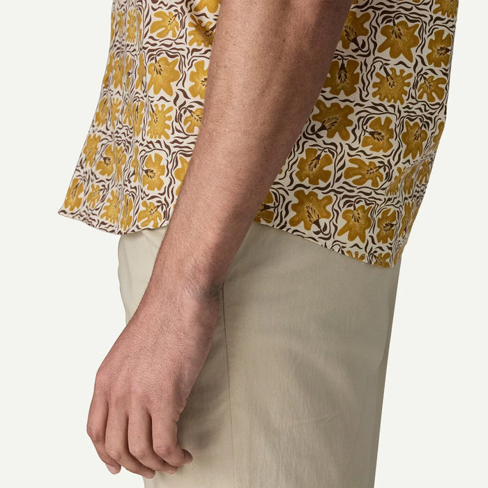 Patagonia floral short sleeve shirt in yellow and cream, shown on man with beige trousers