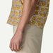Patagonia floral short sleeve shirt in yellow and cream, shown on man with beige trousers