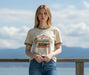 Person wearing a Patagonia t-shirt standing by a wooden railing with a scenic background