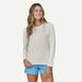 Patagonia long sleeve light grey watersports shirt with logo, worn by woman in blue shorts