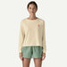 Woman wearing cream long-sleeve Patagonia organic shirt and green board shorts