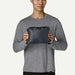 Man holding packed black Patagonia Nano Puff Hoody, compact surf clothing for watersports.