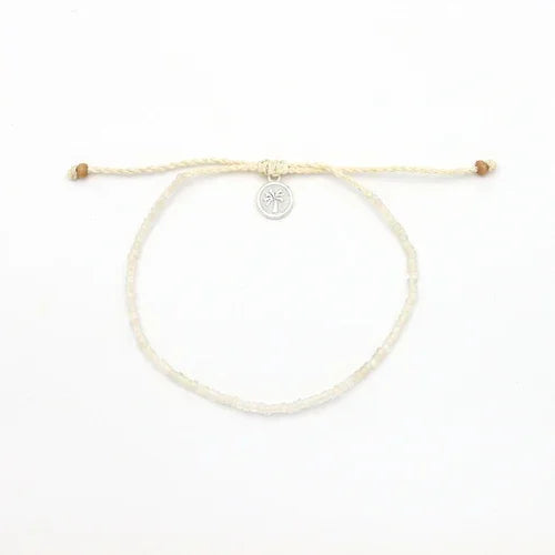 Pineapple Island shell bracelet set with cream cord and silver palm tree charm on white background