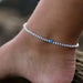 blue and white beaded anklet with eye charm on ankle, ideal surf jewelry for beachwear