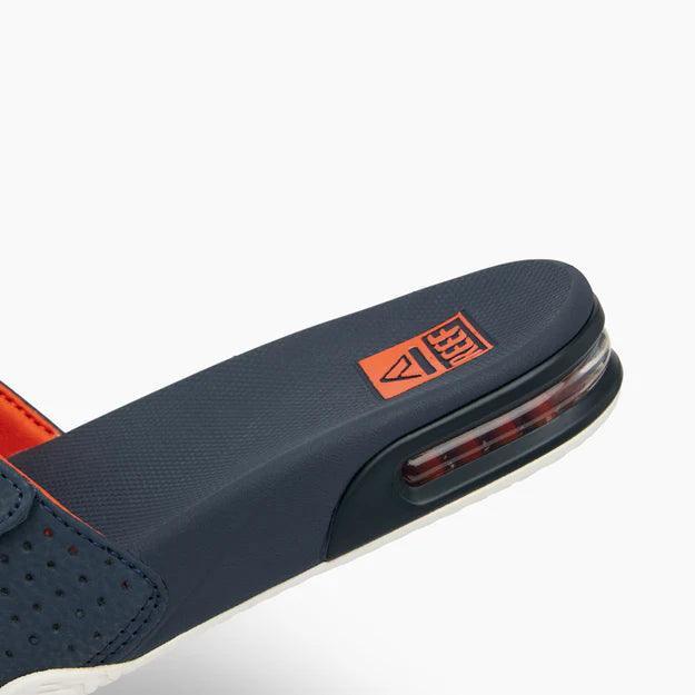 Reef Fanning slide sandal in navy, orange, and white with visible air cushion heel