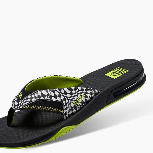Reef Fanning flip flop with black and white checker strap and neon yellow accents, visible logo