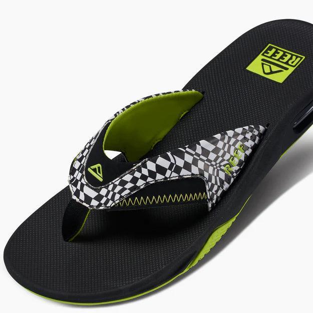 Reef Fanning men's flip flop with black and white checker strap and neon green accents