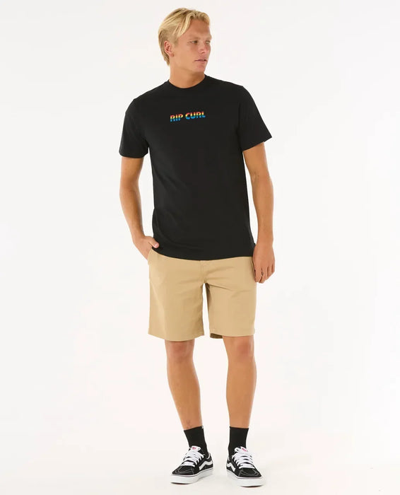 Rip Curl black t-shirt with colourful logo, worn by man in beige shorts, surf clothing