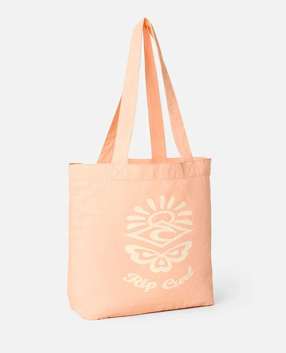 Peach tote bag with a white logo and text on a light gray background